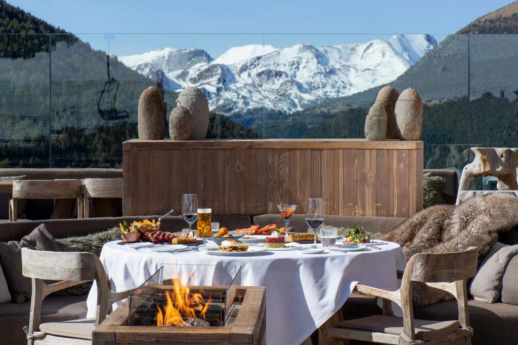 Table set with a fire pit next to it with view to the mountains