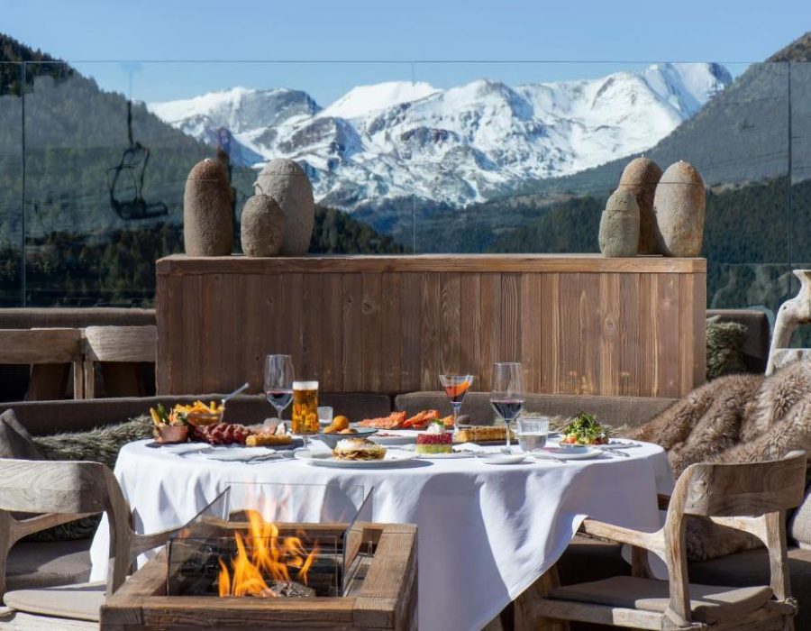 Table set with a fire pit next to it with view to the mountains